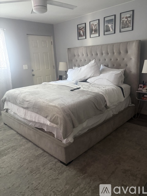 A bedroom with a large bed and a ceiling fan.