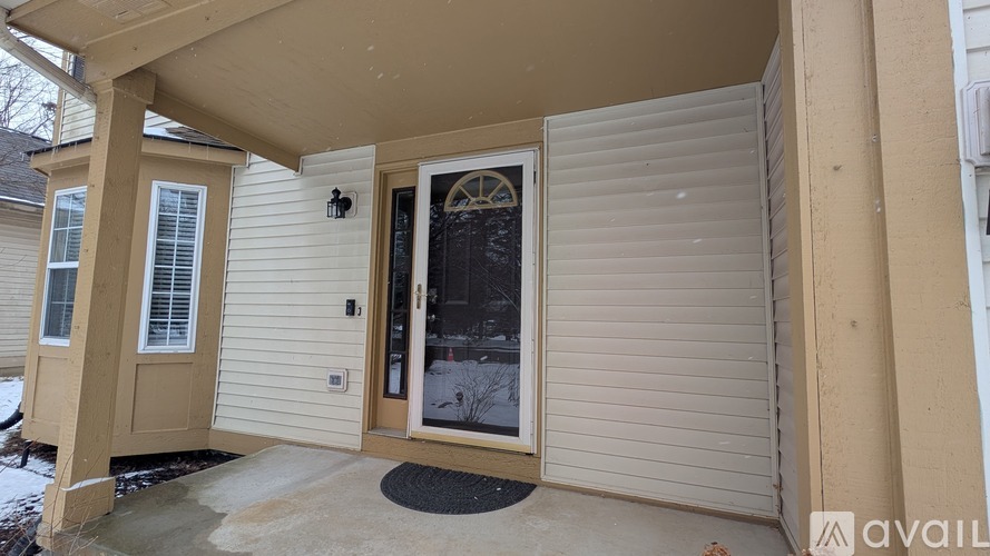 A beige house with a black door and a window.
