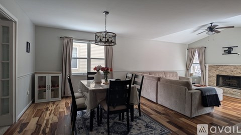 A living room with a dining table set up with chairs around it.