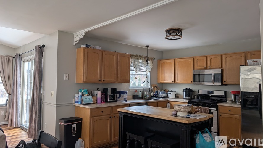 A kitchen with wooden cabinets and black appliances.
