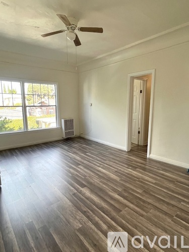 A room with wooden flooring and a ceiling fan.