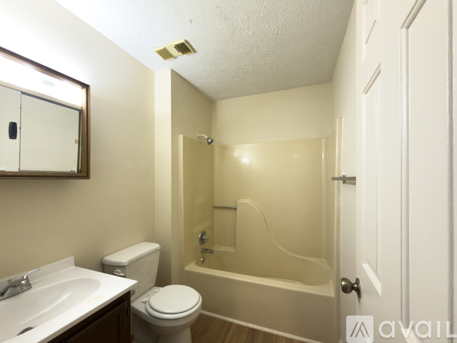 A bathroom with a toilet, sink, and bathtub.