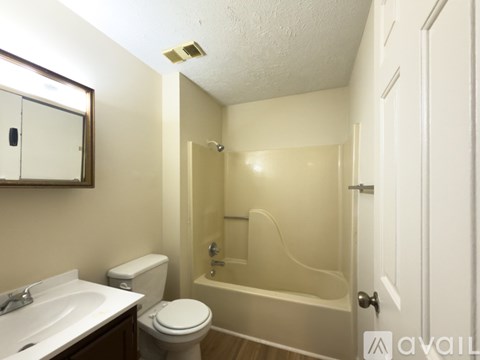 A bathroom with a toilet, sink, and bathtub.
