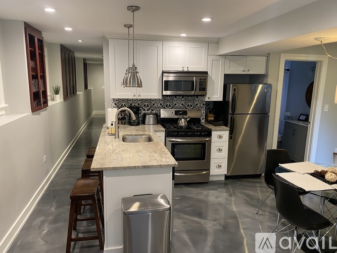 A modern kitchen with stainless steel appliances and a marble countertop.