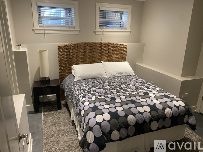 A bedroom with a bed covered in a polka dot comforter.