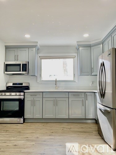A kitchen with a stove, oven, microwave, and refrigerator.