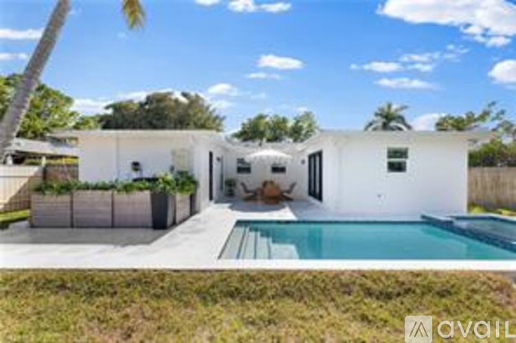 A modern white house with a pool in the backyard.
