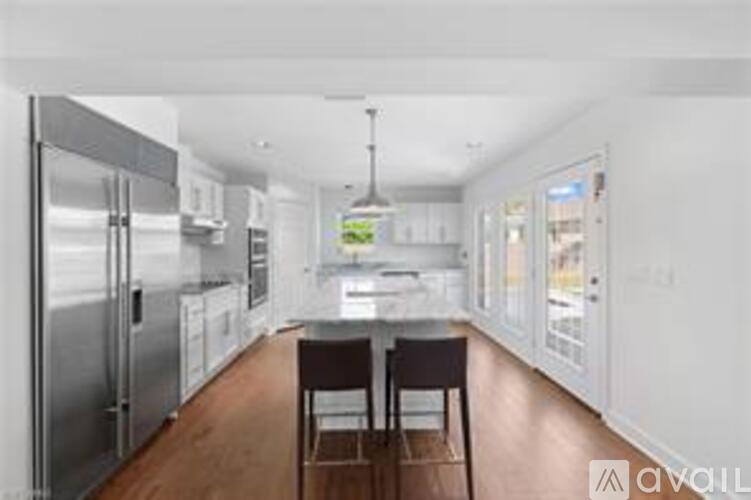 A kitchen with a table and chairs in the middle of the room.
