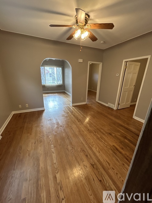 A room with wooden flooring and a ceiling fan.