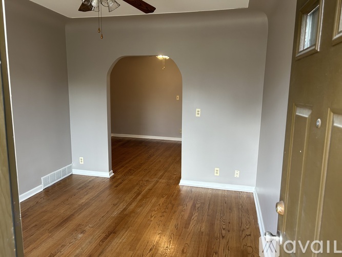 A room with wooden flooring and a ceiling fan.