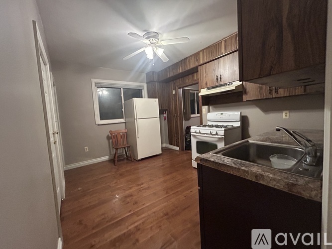 A kitchen with wooden floors and a ceiling fan.