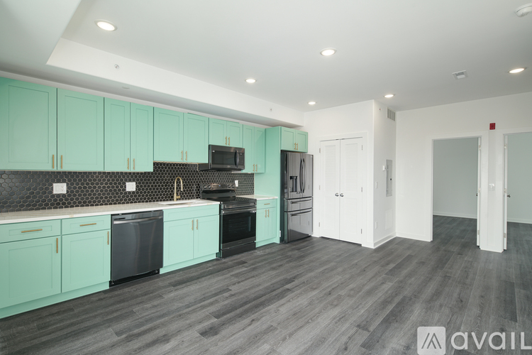 A kitchen with teal cabinets and a black countertop.