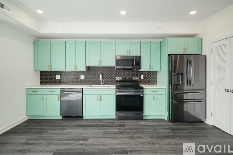 A kitchen with teal cabinets and a black dishwasher.
