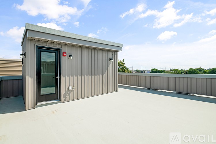 A small building with a door and a window is on a rooftop.