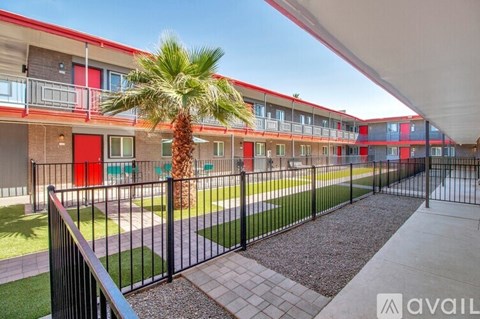 A row of modern apartment buildings with a palm tree in the foreground.