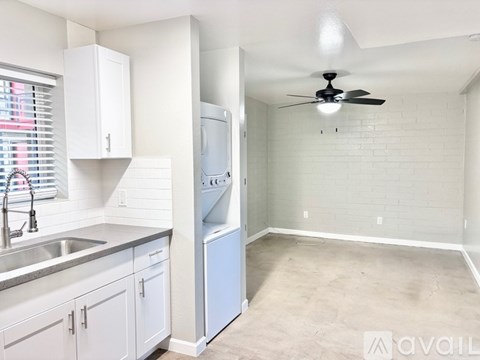 A kitchen with white cabinets and a stainless steel sink.