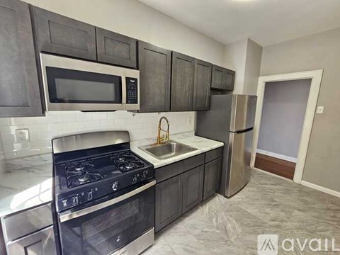 A kitchen with a stove, microwave, and refrigerator.