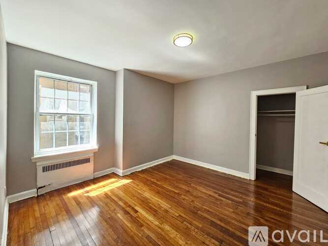 A room with wooden floors and a window with a white frame.