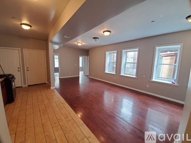 A spacious room with wooden floors and white walls.