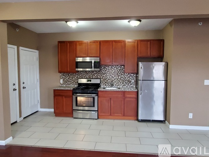 A kitchen with brown cabinets and a silver refrigerator.