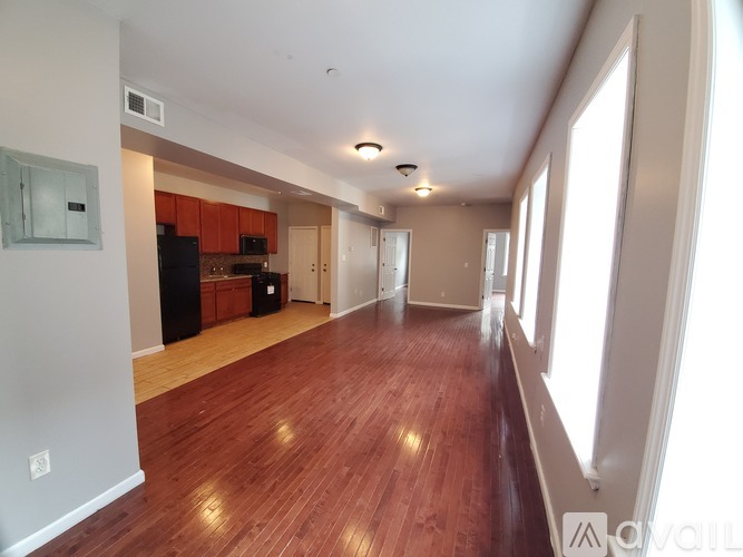 A long hallway with wood floors and white walls.