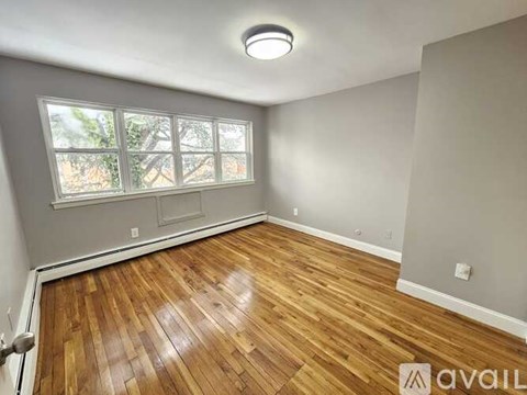 A room with wooden flooring and a window.