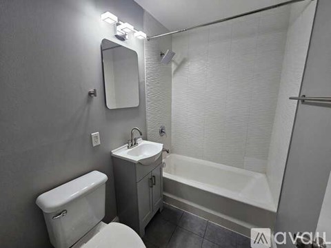 A white toilet sits next to a sink in a small bathroom.