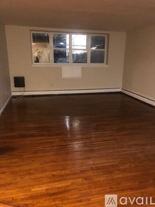 A room with wooden flooring and a window.