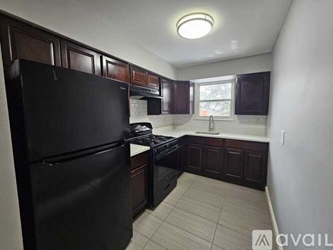 A kitchen with black appliances and brown cabinets.
