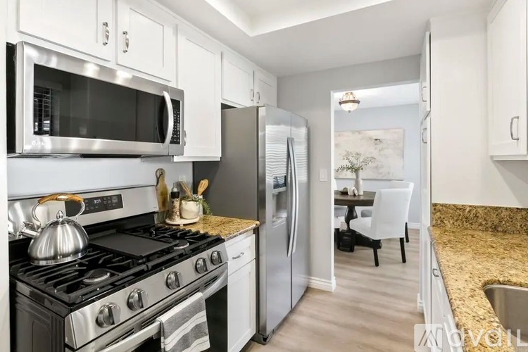 A modern kitchen with a stove top oven, microwave, and refrigerator.