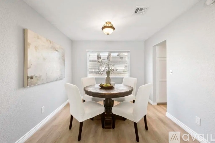 A dining room with a round table and chairs.