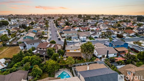 A bird's eye view of a residential neighborhood with houses and a swimming pool.