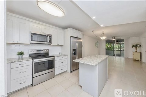 A modern kitchen with white cabinets and appliances.