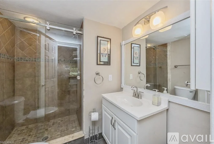 A bathroom with a walk-in shower and double sinks.
