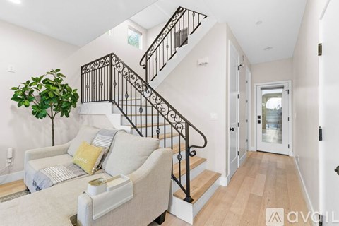 A living room with a couch and a staircase.