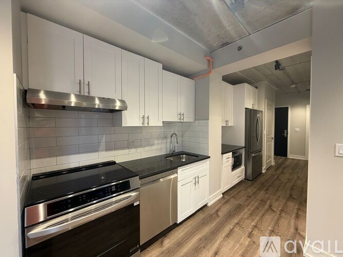 A kitchen with white cabinets and a black stove top oven.