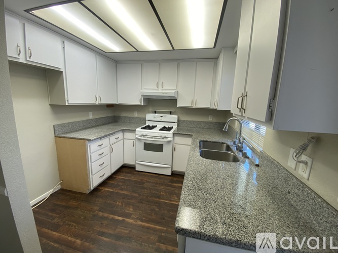 A kitchen with white cabinets and a granite countertop.
