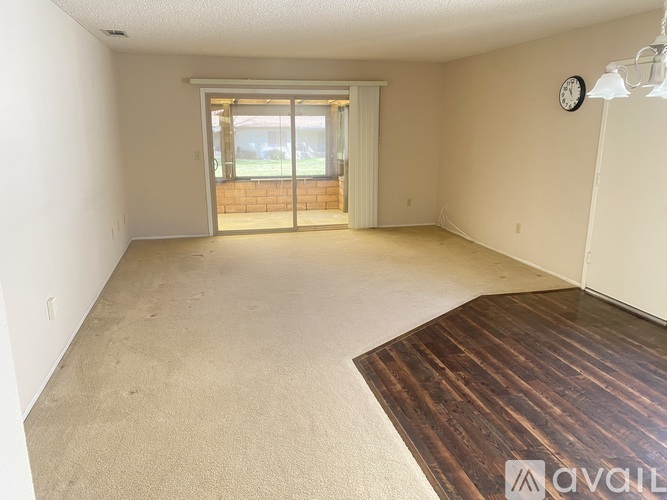A room with a carpeted floor and a wooden floor in the corner.