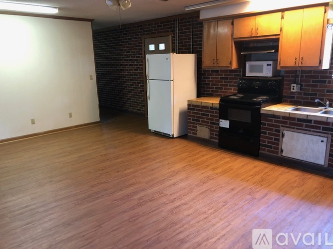 A kitchen with a white fridge and black stove.