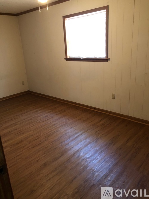 A room with wooden flooring and a window.