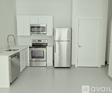 A kitchen with a refrigerator, oven, microwave, and sink.