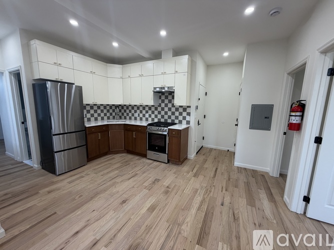 A kitchen with wooden floors and a black and white checkered backsplash.