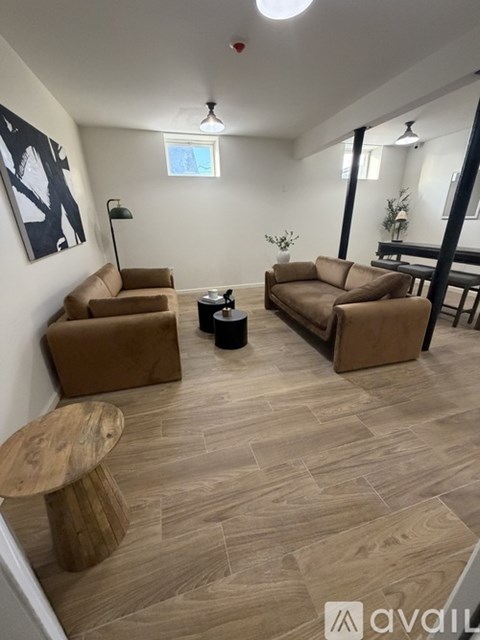 A living room with a brown sofa and a wooden table.