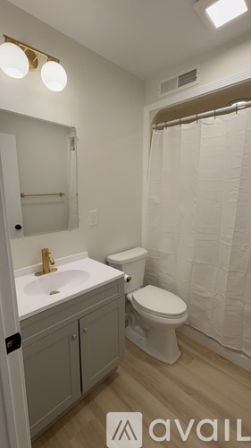A bathroom with a toilet, sink, and shower.