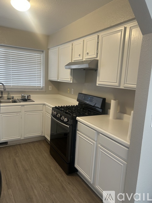 A kitchen with white cabinets and a black stove top oven.
