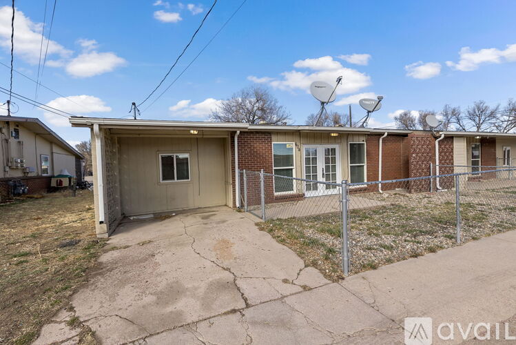 A house with a fence and a driveway in front of it.
