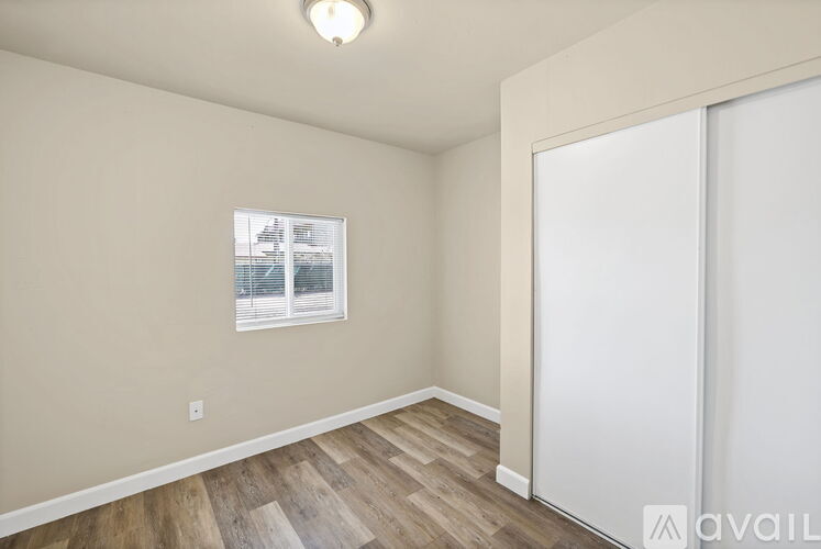 A room with a sliding door and a window with a view of a building outside.