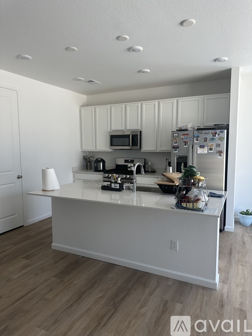 A kitchen with white cabinets and a white island.