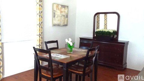 A dining room with a wooden table and chairs.