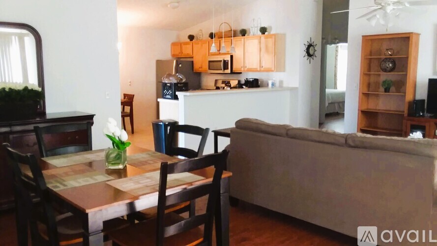 A dining table with chairs and a couch in a living room.
